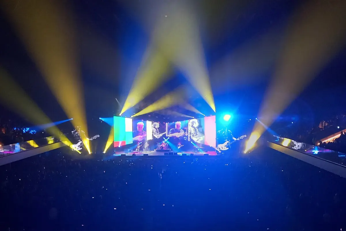 Stage lights sweeping over the crowd at a Movistar Arena concert